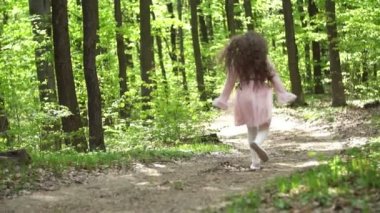 Kız orman yolunda koşuyor.