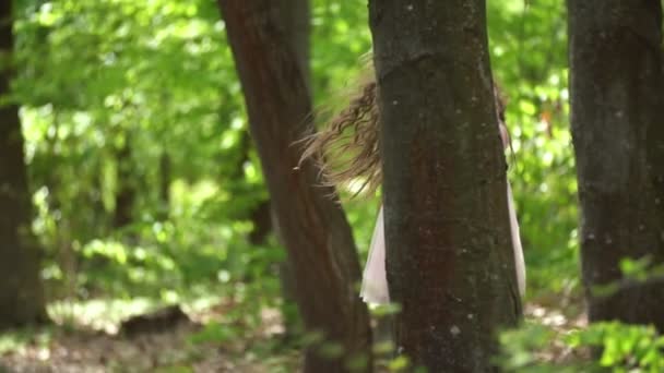 Chica escondida detrás de un árbol — Vídeos de Stock