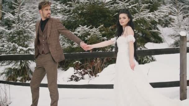 Débilmente vestido pareja cabalgando en la nieve — Vídeos de Stock