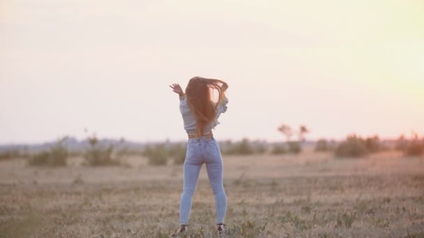 Дівчина в джинсовому одязі, що йде в природі — стокове відео