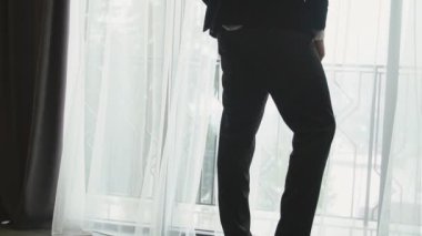 Adam pencerenin yanında duruyor.