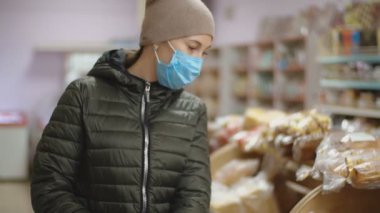 Süpermarketteki tıbbi maskeli kadın.