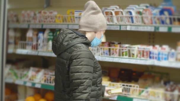 Vrouw met beschermend masker kiest melkproducten — Stockvideo