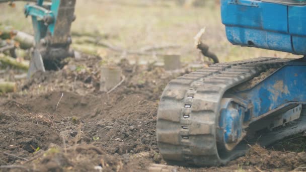 Close-up van een rubberen spoor van een kleine graafmachine — Stockvideo