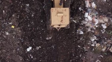 Buldozer bir yığın çöp topluyor.