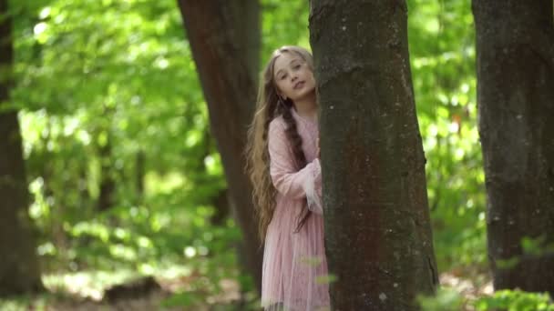 Fille se cachant derrière un arbre — Video