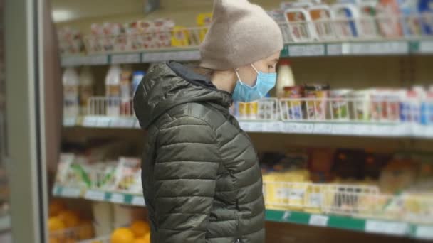 Vrouw met beschermend masker kiest melkproducten — Stockvideo