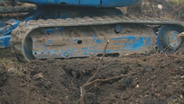 Close-up van een rubberen spoor van een kleine graafmachine — Stockvideo