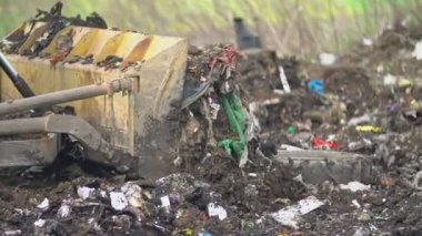 Çöpleri iten buldozer küreği