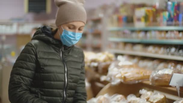 Frau mit Arztmaske im Supermarkt — Stockvideo