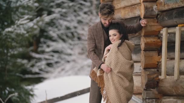Пара стоит рядом с деревянным домом — стоковое видео