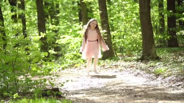 Дівчина біжить лісовою дорогою — стокове відео