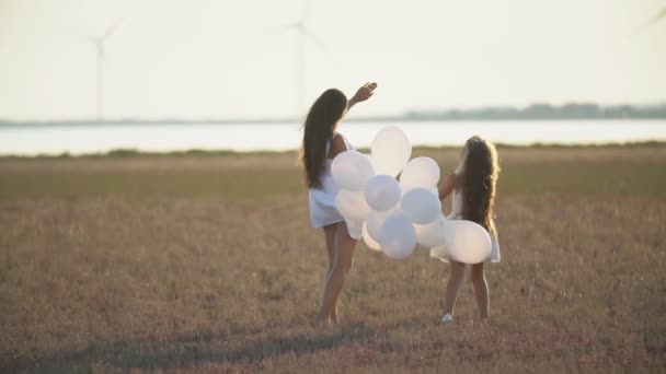 Mor med dotter och ballonger gå i naturen — Stockvideo