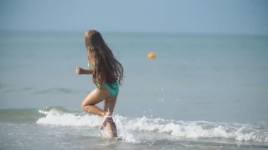 Kız denizde koşuyor.
