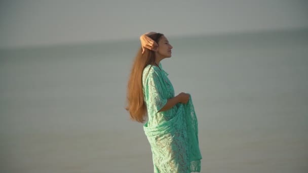 Mujer en un albornoz caminando por el mar — Vídeos de Stock