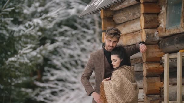 Ζευγάρι στέκεται κοντά σε ένα ξύλινο σπίτι — Αρχείο Βίντεο