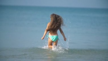 Kız denizde koşuyor.