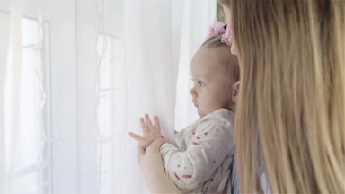 Pencerenin duran ve dışında arıyorsunuz küçük bebek kızı annesiyle