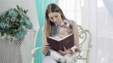 Anne ve kızı birlikte kitap okuyorlar.