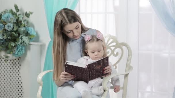 Μητέρα και κόρη διαβάζουν ένα βιβλίο μαζί. — Αρχείο Βίντεο
