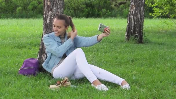 Mujer tomando fotos de sí misma con el teléfono inteligente en el parque — Vídeos de Stock