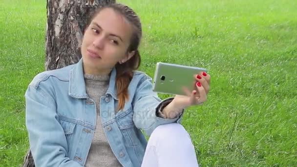 Flicka skjuter sig själv i parken. Selfie — Stockvideo