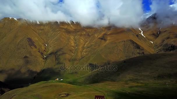 Monte Kazbek. Vista desde arriba en un valle de montaña verde y pueblo de montaña — Vídeo de stock