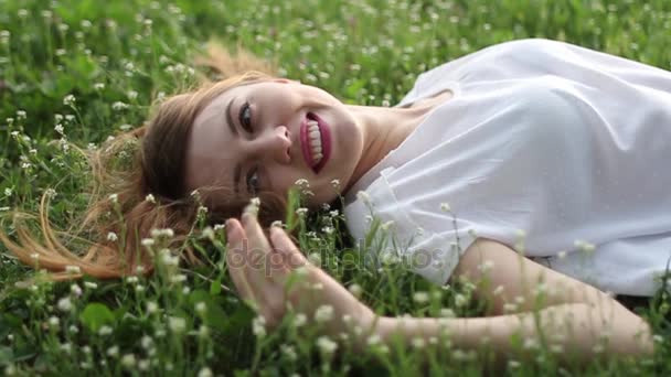 Мрійлива приваблива молода жінка з квітами відпочиває зовні — стокове відео