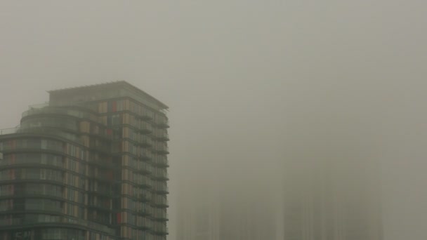 Wolkenkratzer am Ufer des Flusses mit Nebel bedeckt. — Stockvideo