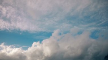 Zaman atlamalı. Beyaz bulutların üstünde mavi bir gökyüzü.