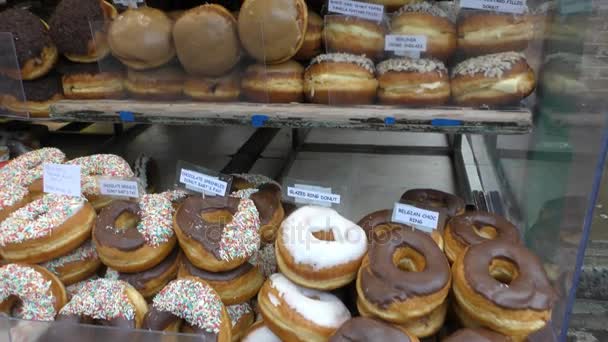 Laden mit verschiedenen leckeren Scones und Donuts. — Stockvideo