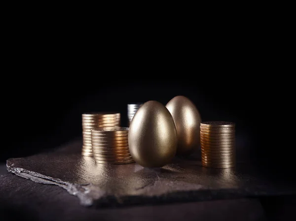 金融投资独特 独创的概念形象 金蛋和堆积起来的硬币在黑色的石板上 有复制的空间 — 图库照片