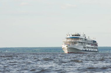 Nehirdeki beyaz gemiyle seyahat eden turist gemisiyle yaz güneşi turizmi eğlencesi.