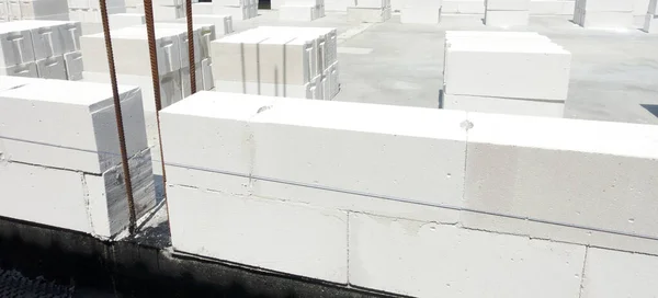 White foamed lightweight concrete (aerated concrete block) wall under construction with steel rebars. — Stock Image White Foamed Lightweight Concrete Aerated Concrete Block Wall Construction Steel Royalty Free Stock Photos