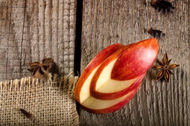 Eski bir ahşap tahta üzerinde anasonlu yıldızlı dekoratif elma dilimi.