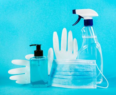 Tıbbi maske, dezenfeksiyon sıvısı, sabun, mavi arka planda lateks eldivenler. Coronavirus koruma konsepti. Kendini koru ve koronavirüse hazır ol.