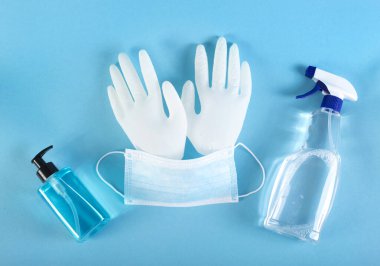 Tıbbi maske, dezenfeksiyon sıvısı, sabun, mavi arka planda lateks eldivenler. Coronavirus koruma konsepti. Kendini koru ve koronavirüse hazır ol.