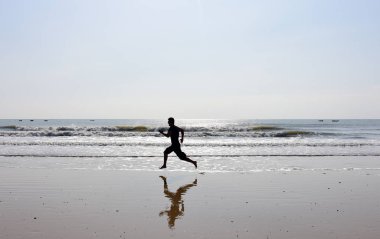 Çıplak ayakları adam plaj dalgalar ile çalışan