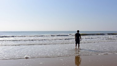 Deniz dalgaları ile ayakta adam