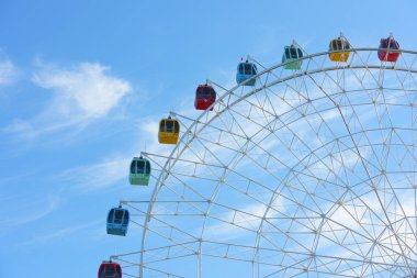 Dönme dolap, gözlem tekerleği mavi gökyüzü ve beyaz bulutlar ile