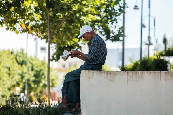 JUNE 10 ,2016 ASILAH -MOROCCO: Man reads the newspaper in the st — Stock Photo, Image