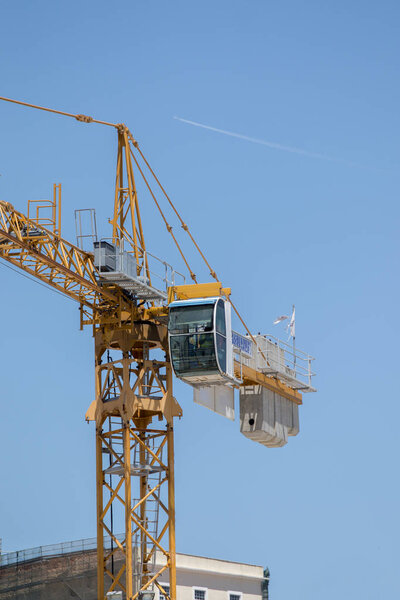 View of one construction crane over a blue sky.