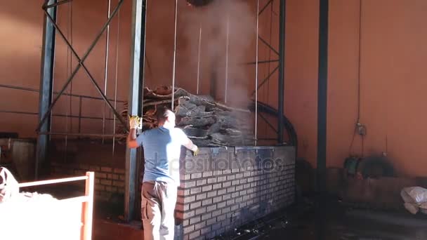 SAO BRAS DE ALPORTEL, PORTUGAL: 14 NOV, 2016 - Trabalhadores preparam um monte de cortiça virgem para submergir em uma caldeira . — Vídeo de Stock