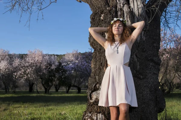 Hermosa mujer junto a un almendro — Foto de Stock