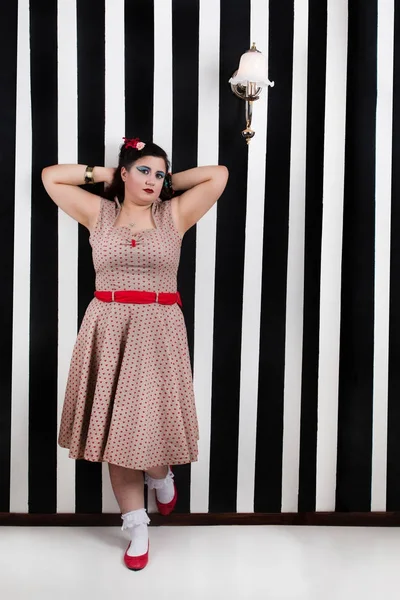 Pinup girl posing on a stripes backdrop — Stock Photo, Image