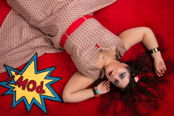 Pinup fille posant sur un lit rouge — Photo