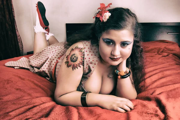 Pinup chica posando en una cama roja —  Fotos de Stock