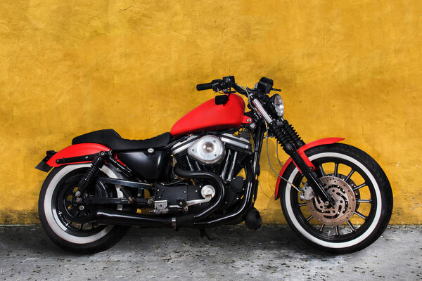 Red motorbike against a yellow wall