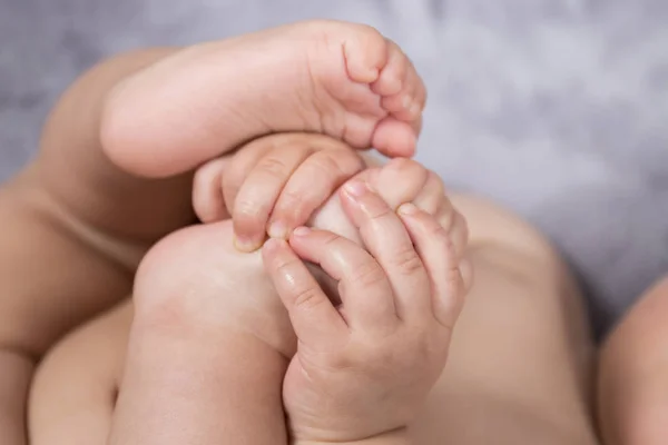Close up of cute and tiny baby feet and hands.