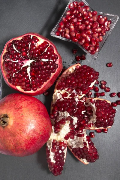 Close Van Smakelijke Granaatappels Bovenop Een Leisteen Steen — Stockfoto